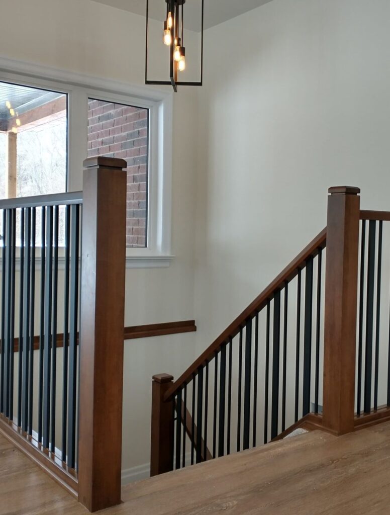 Dark wood railing posts with black metal balusters beside a staircase