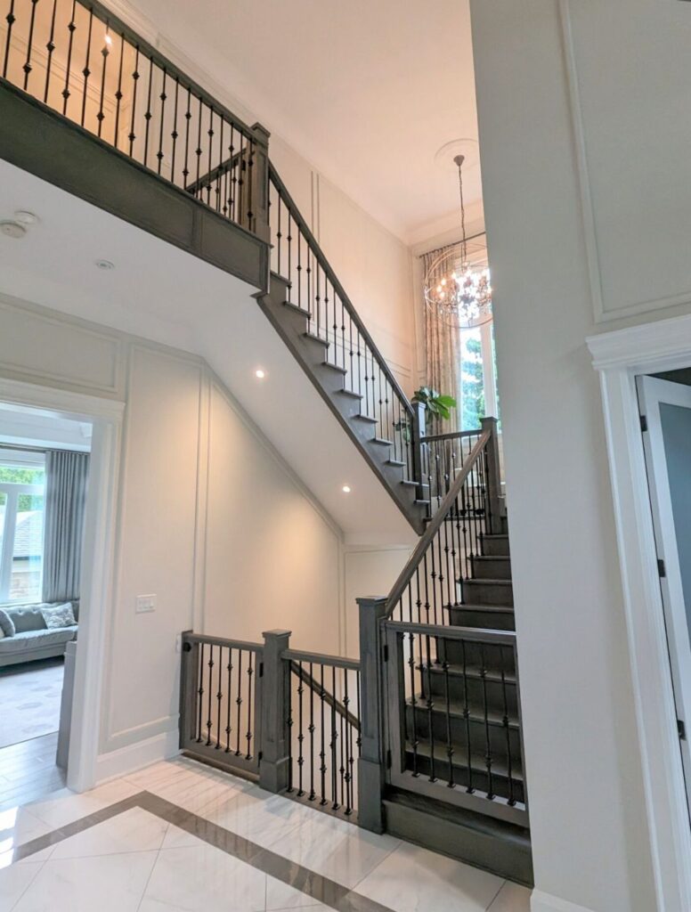 Multi-level dark wood staircase with black metal railings in a bright interior