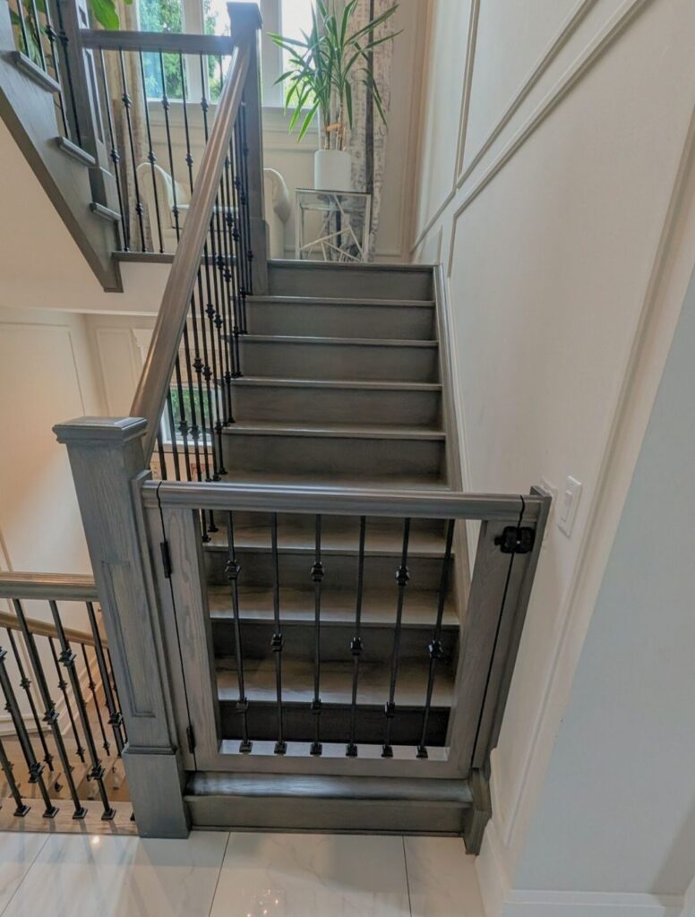 Dark wood staircase with black metal balusters and matching railing